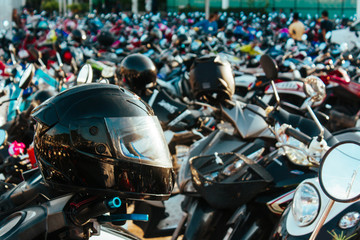 The helmets on the scooters. The helmets placed on a parked scooters in the retail store....