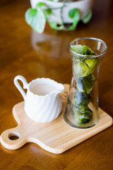 matcha green tea ice cubes with fresh milk on wooden table
