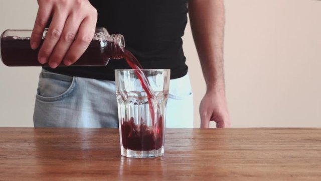 Pouring cherry juice into glass