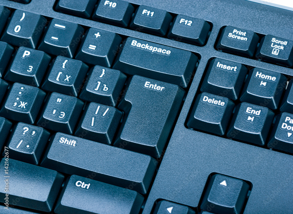 Poster electronic collection - black computer keyboard. the focus on the enter key. toning is blue.