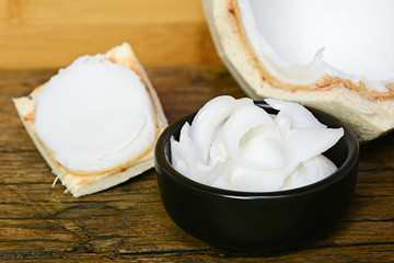 young coconut meat sliced in bowl on wooden table © ipuwadol