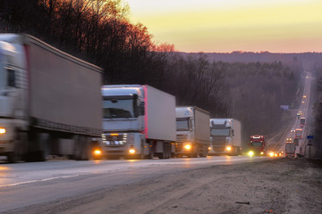 Trucks on a highway in an evening