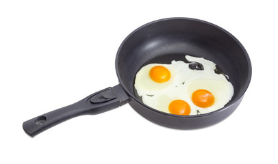 Three fried eggs on the frying pan during cooking