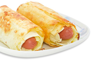 Two baked sausage rolls on dish closeup
