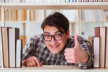 Young student looking for books in college library