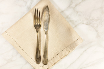 Vintage fork and knife on white marble table with copyspace