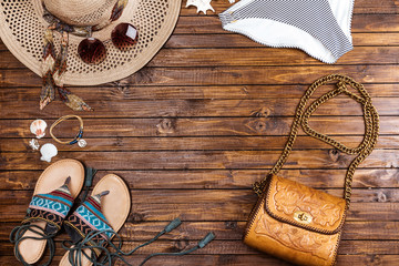 top view of swimming pants, straw hat, sunglasses, sandals and bag on table