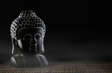 Buddha Kopf auf Bambusuntergrund mit Nebel