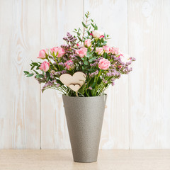 Spring bouquet in a round box on a wooden background. Copyspace