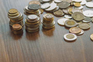 Different gold and silver collector's coins on the wooden table