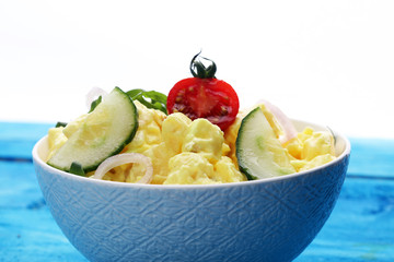 A delicious homemade creamy potato salad on a picnic table.
