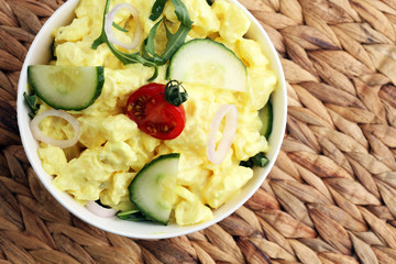A delicious homemade creamy potato salad on a picnic table.