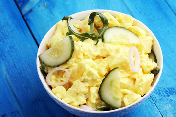 A delicious homemade creamy potato salad on a picnic table.