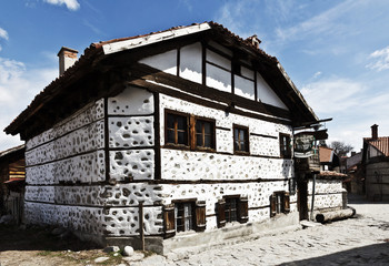 Old house stone paved road alley, wooden benches Bansko ski tourist centre of Bulgaria 