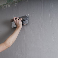 Hands Plasterer at work. Application of the plaster on the wall. textured plaster