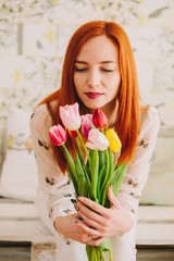 red-haired girl holding a bouquet of tulips