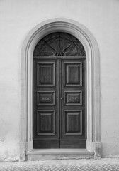 Wooden door in an old Italian house, copy-space, black and white.