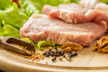 Slices of raw meat. Pork escalope on a wooden board.