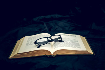 Glasses on old book