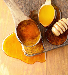 Assortment of three types of honey on wooden board, rustic background.Top view.