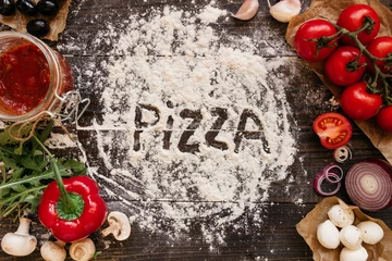 Foto op Plexiglas Pizzeria Pizzakoken. Pizza-ingrediënten op de houten tafel, bovenaanzicht