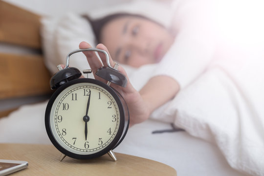 women turn off alarm clock in the morning