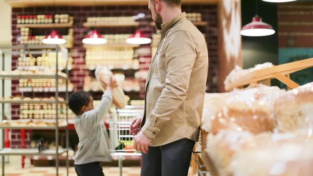 Father and son buying bread in grocery store