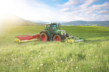 Traktor mäht Gras für Silage im Allgäu
