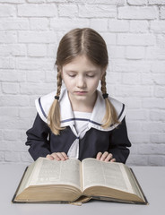 dziewczynka z książką w mundurku szkolnym - obrazy, fototapety, plakaty