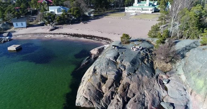Old Canon, Cinema 4k aerial flight away from a old canon, on a cliff, near hanko casino, on a sunny spring day, in Hango, Finland