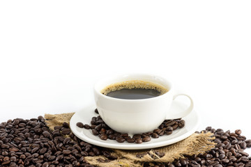 Obraz premium Coffee cup with beans on hemp sack