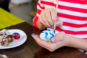 Girl painting easter egg