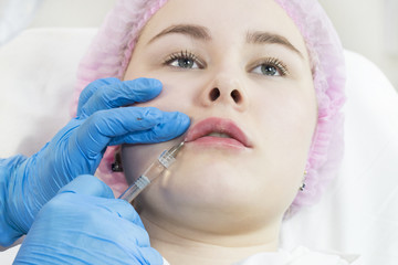 Naklejka premium The process of cosmetic surgery of water injection in the area of the lips of a woman 