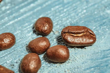 Dark many roasted coffee beans on blue background