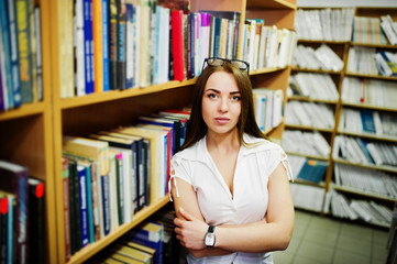 Brunette girl at library, wear on white blouse and black mini skirt. Sexy business woman or teacher concept.
