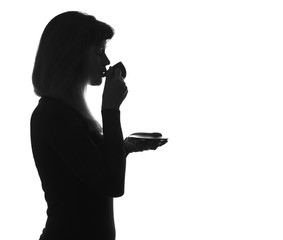 silhouette of young woman drinking coffee