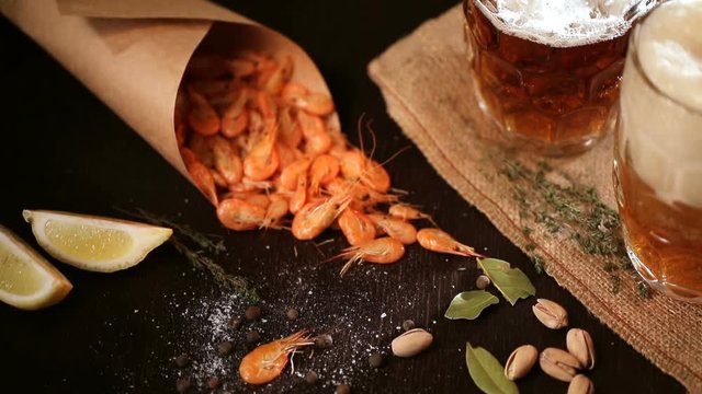 Fills the glass of Beer mug and grilled shrimps on wooden table