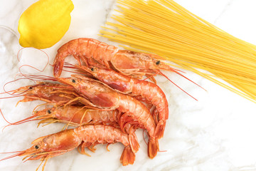 Raw shrimps with lemon, pasta, and copyspace