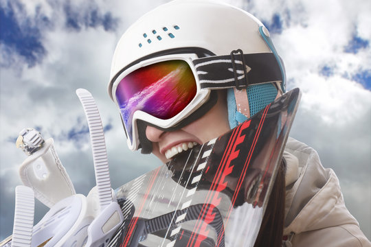 Young Girl Snowboarder In Helmet And Goggles Bites Snowboard