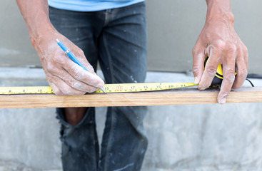 Fototapeta na wymiar Carpenter hand measuring tape with pencil
