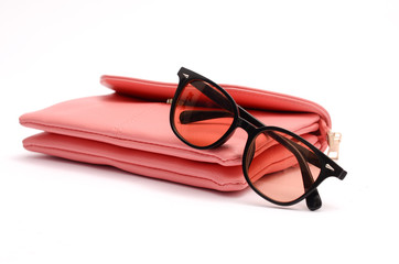 Pink leather clutch and sunglasses still life