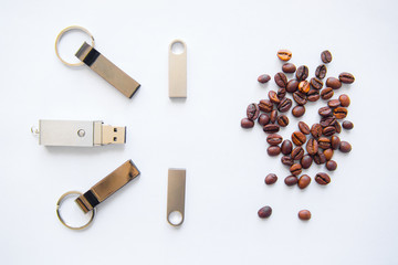 USB stick and coffee beans on white background.