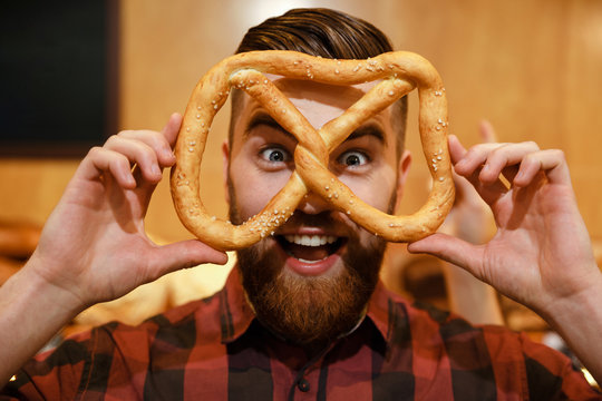 Cheerful Funny Man In Supermarket Holding Pretzel.