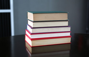 stack of hardcover books on wooden table