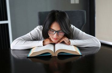 Young asian student reading a book under mental pressure