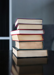 stack of hardcover books on wooden table. Education background.