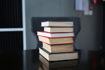 stack of hardcover books on wooden table. Education background.