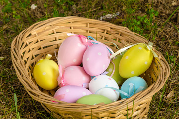 Pastel Coloured Easter Eggs in a Basket on Grass