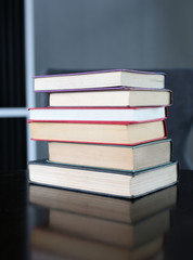 stack of hardcover books on wooden table. Education background.