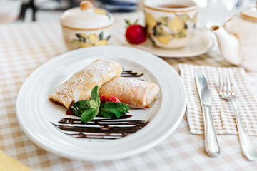 Pancakes with chocolate, fresh strawberry and mint